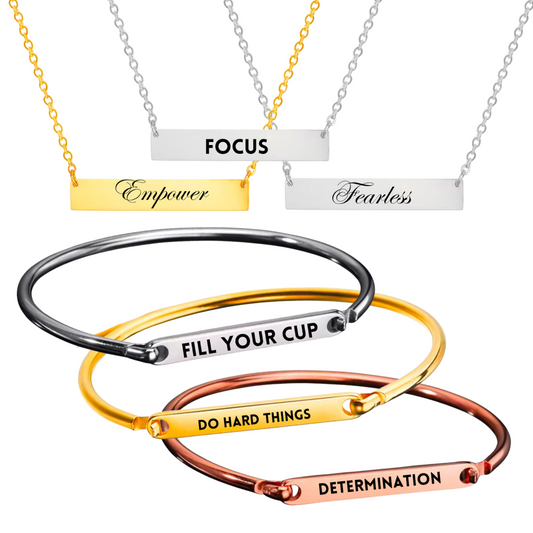 Personalized bracelets and necklaces in silver, gold, and rose gold finishes featuring custom-engraved words such as 'FOCUS,' 'FEARLESS,' 'EMPOWER,' 'FILL YOUR CUP,' 'DO HARD THINGS,' and 'DETERMINATION.' Elegant and durable stainless steel jewelry designed for inspiration and intention.